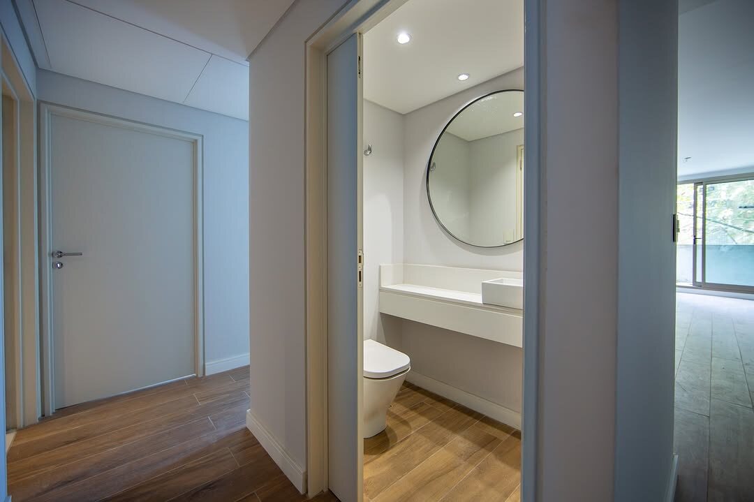 Baño de huéspedes con espejo circular